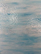 Textured blue and white glass surface with small rust spots
