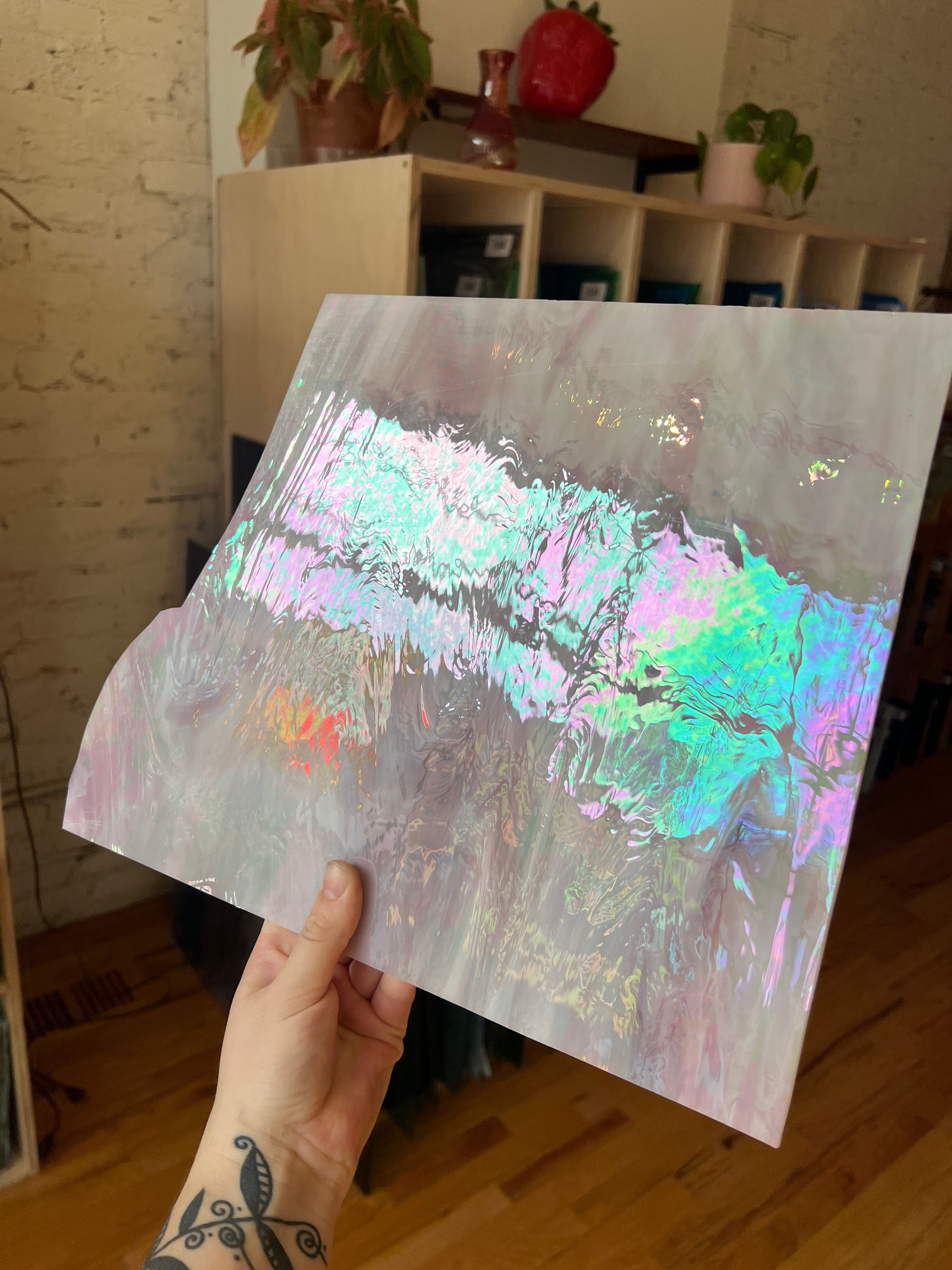 Holographic sheet of glass held by a person with a blurred indoor background