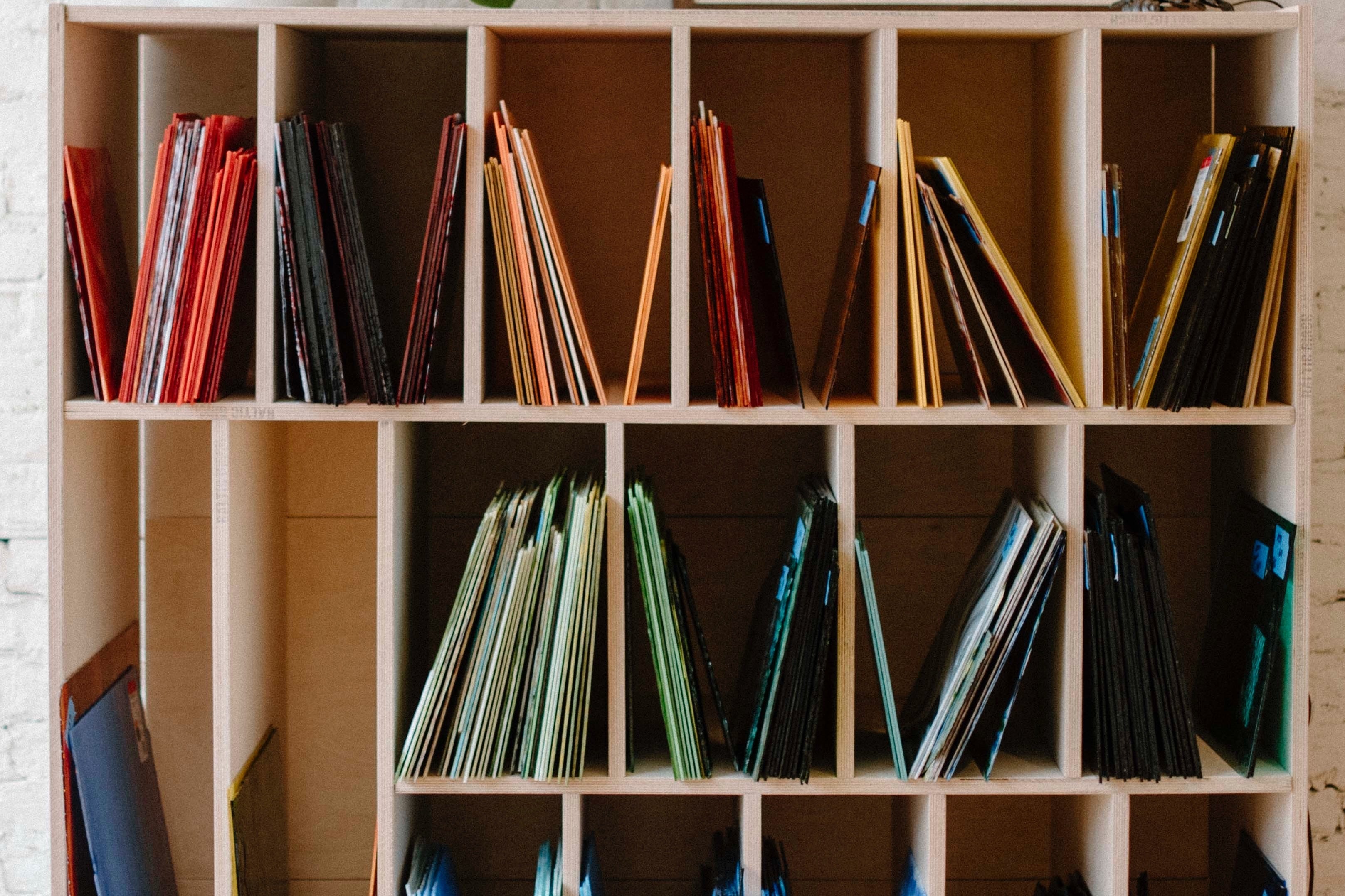 Wooden bookshelf with stained glass arranged in rows.