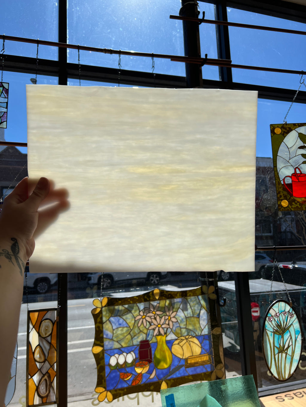 Sheet of white glass held up with stained glass windows in the background