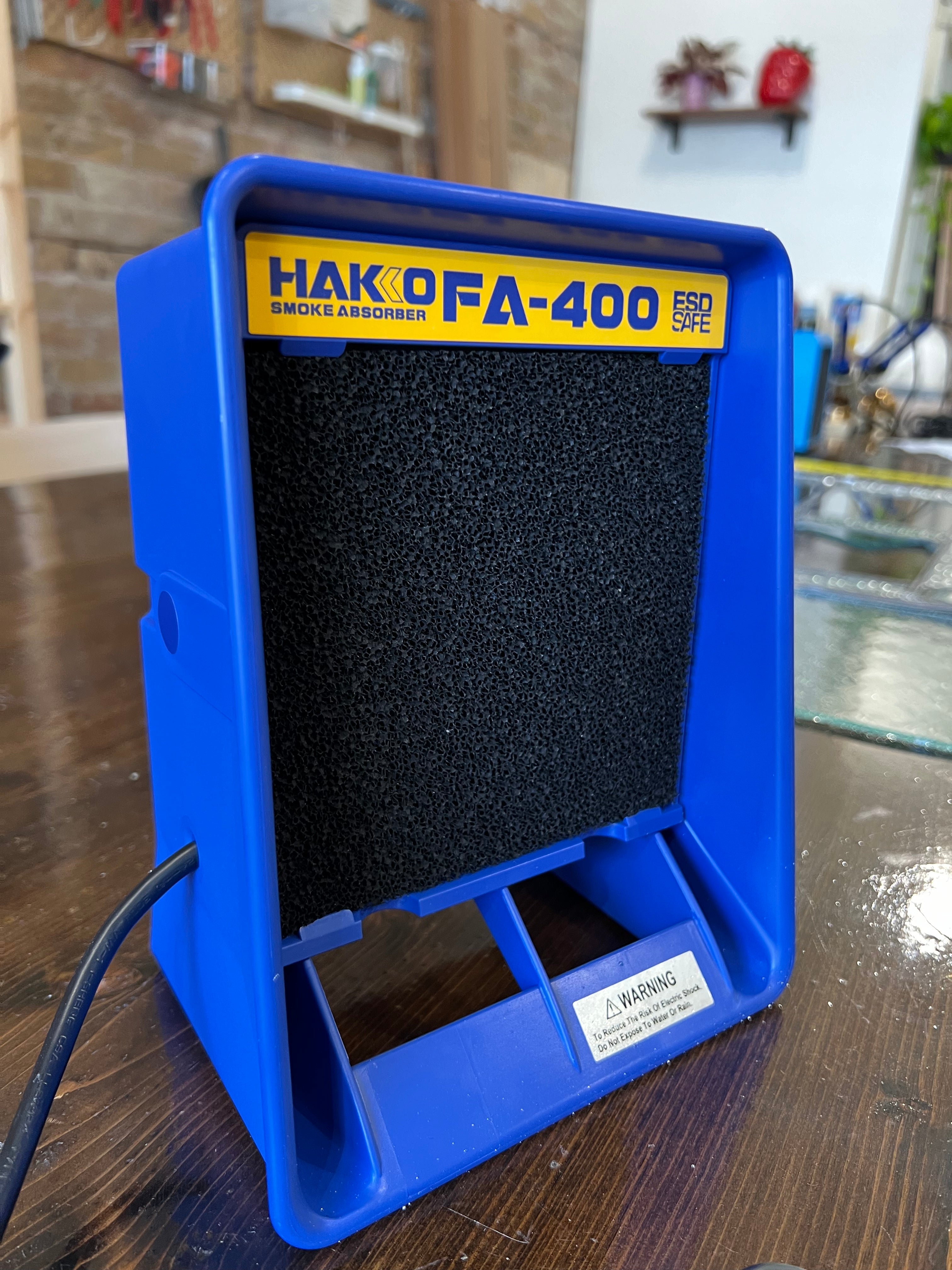 Blue Hakko FA-400 smoke absorber on a wooden surface.