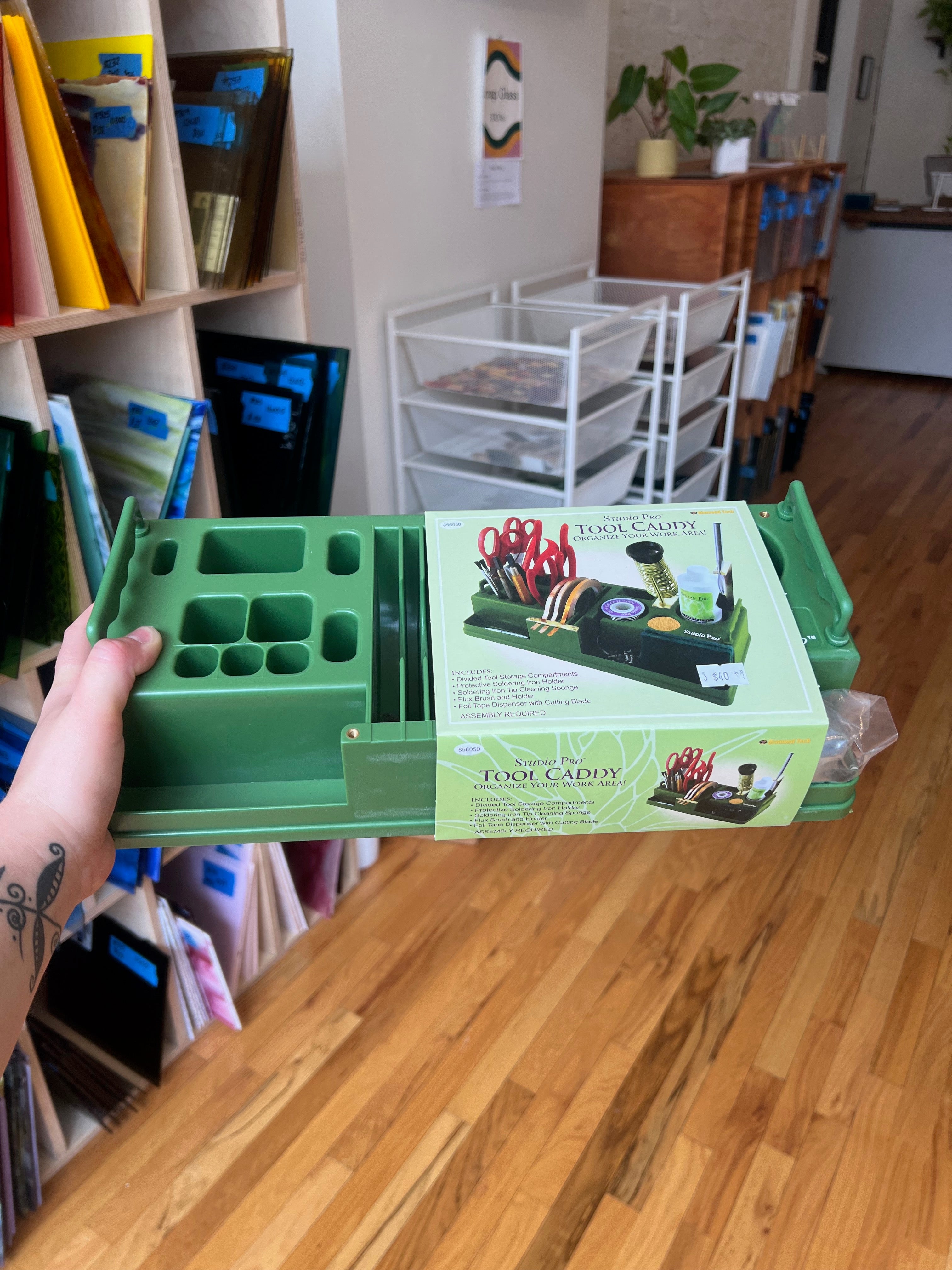 Green tool caddy with tools on a wooden surface in a room setting
