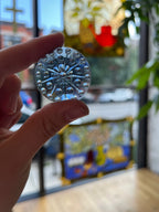 Hand holding a gem with a blurred indoor background