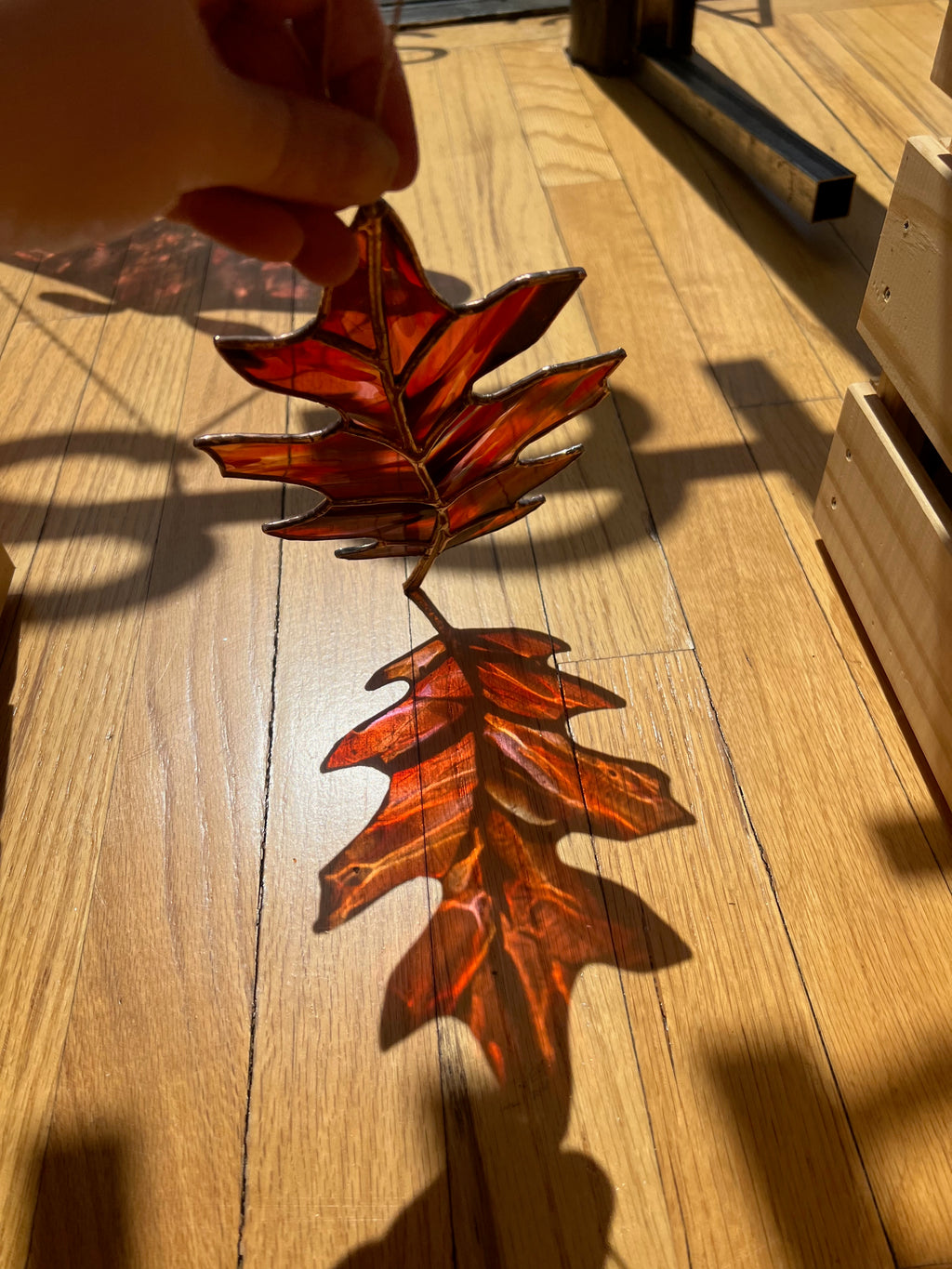 Decorative stained glass leaf on a wooden floor