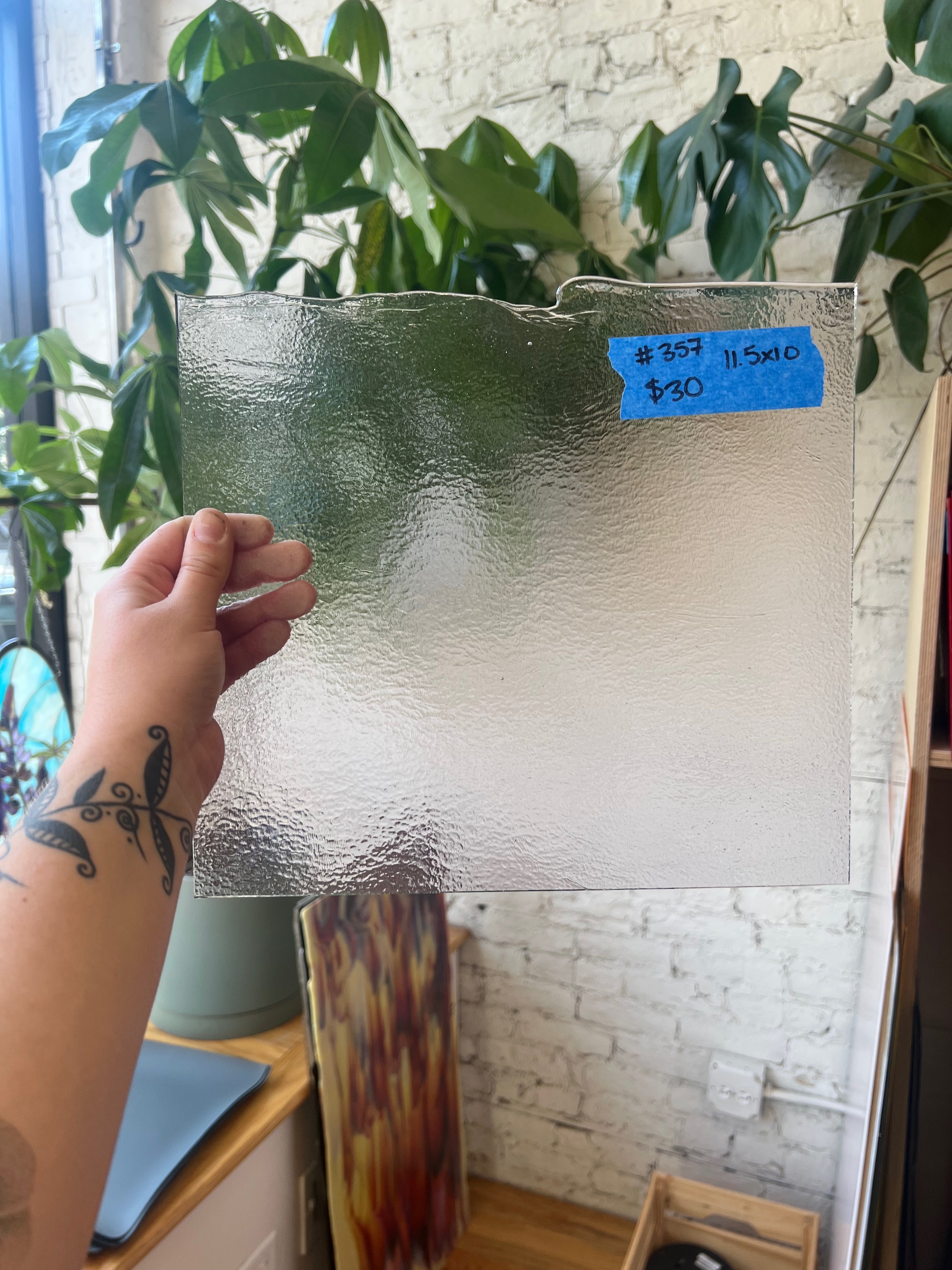Person holding a sheet of glass with a price tag in a store setting