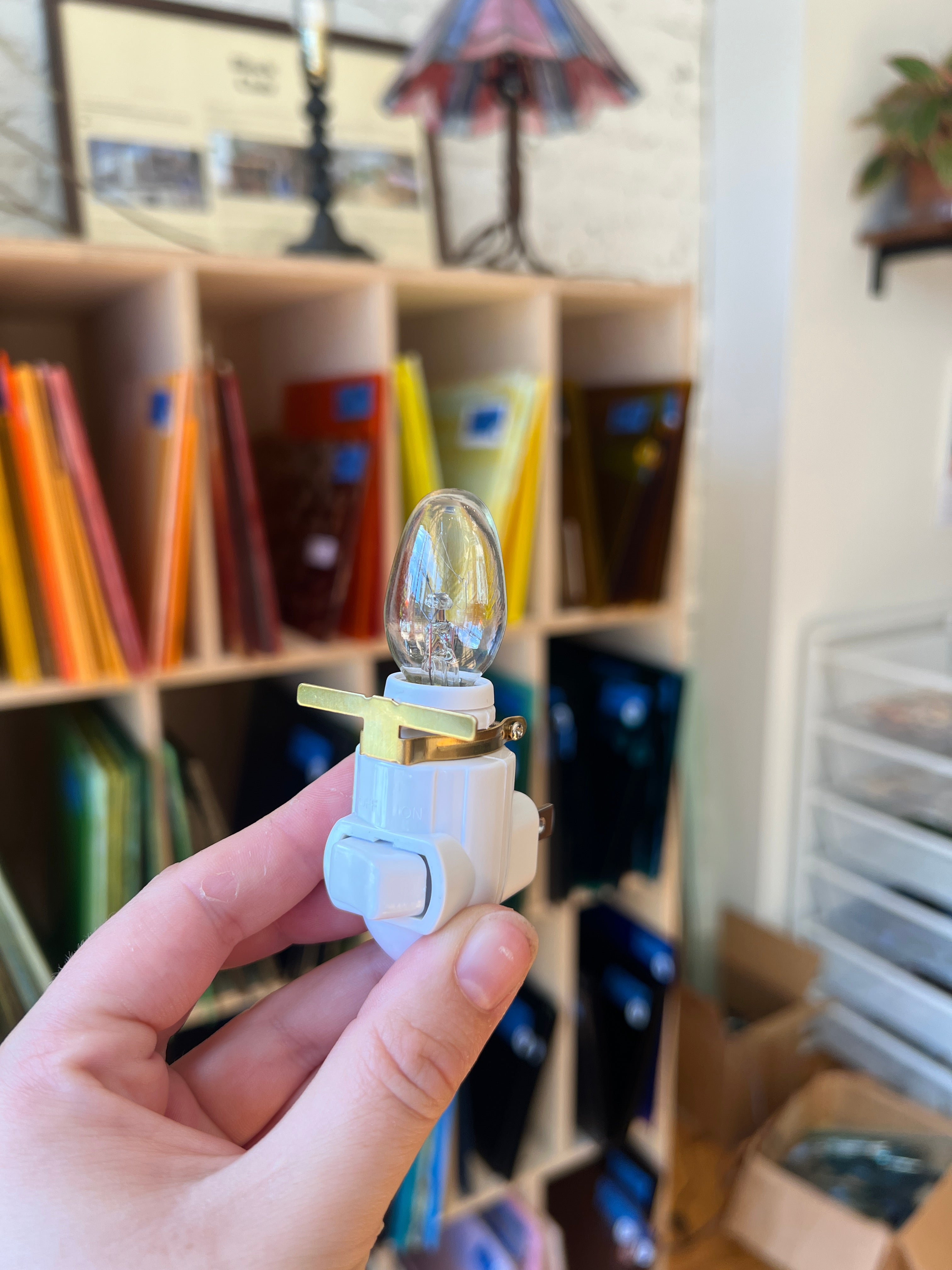 Hand holding a small electronic device with a blurred background