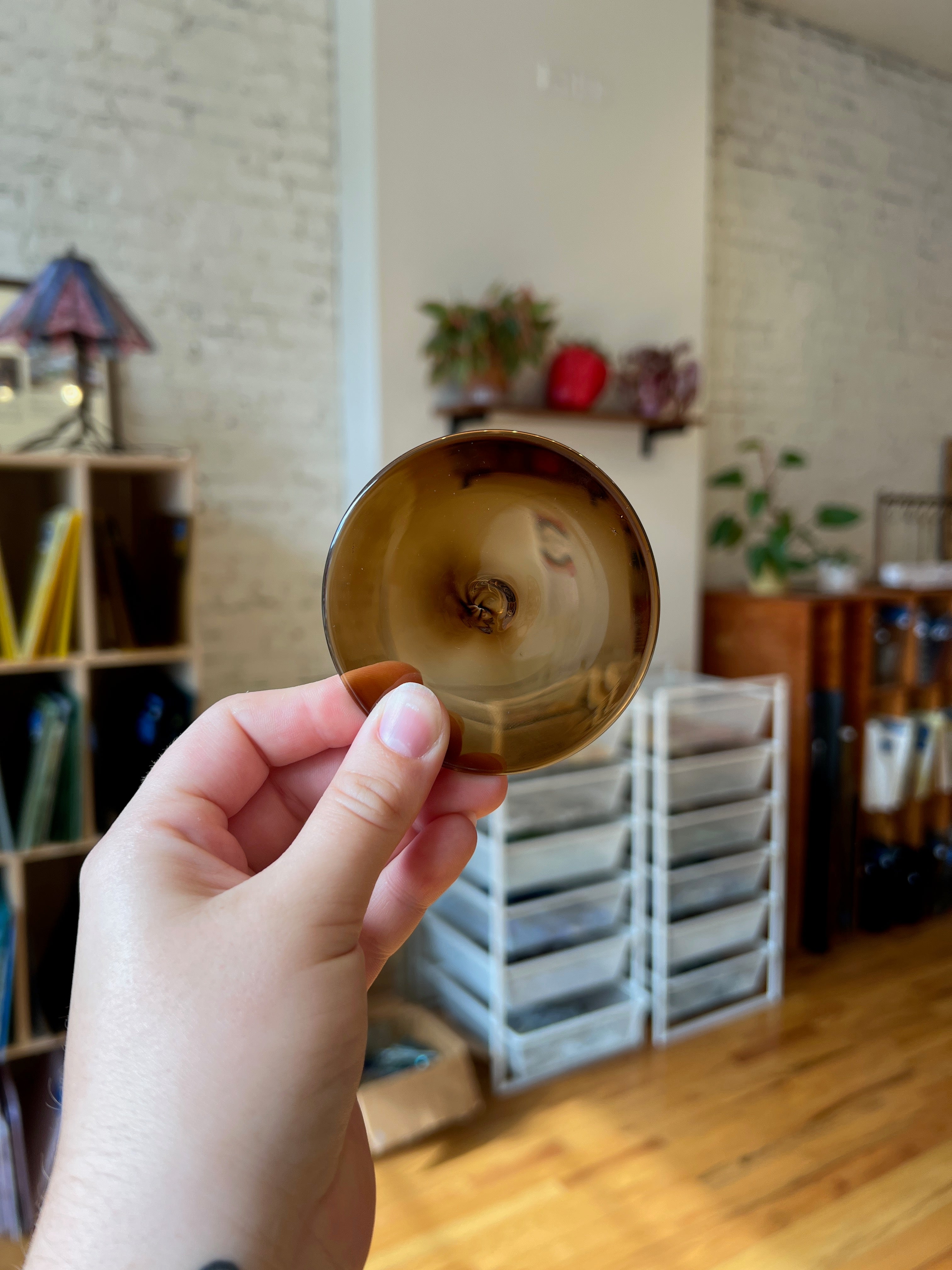Hand holding a rondel with a blurred indoor background