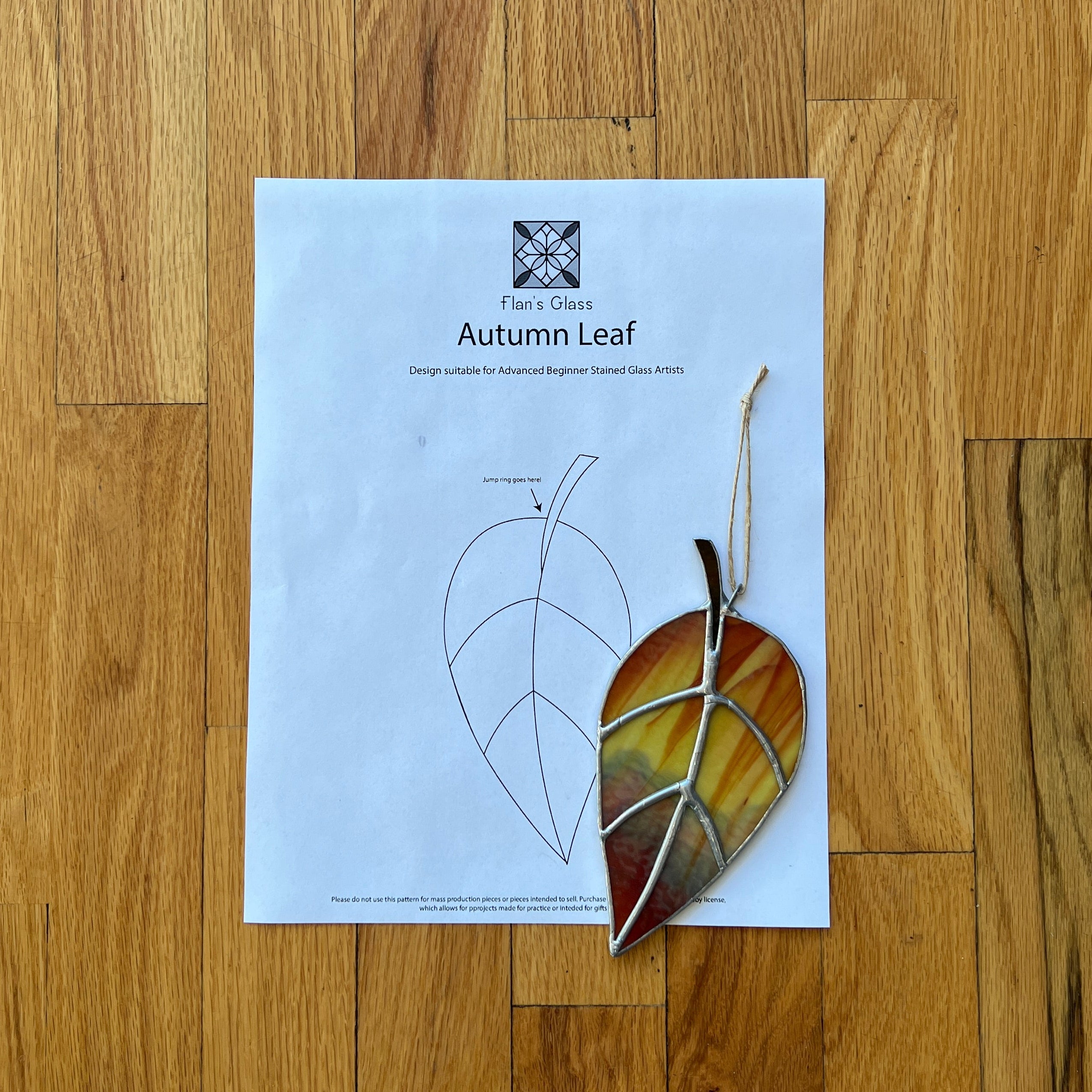 Sheet of paper with a leaf design on a wooden floor