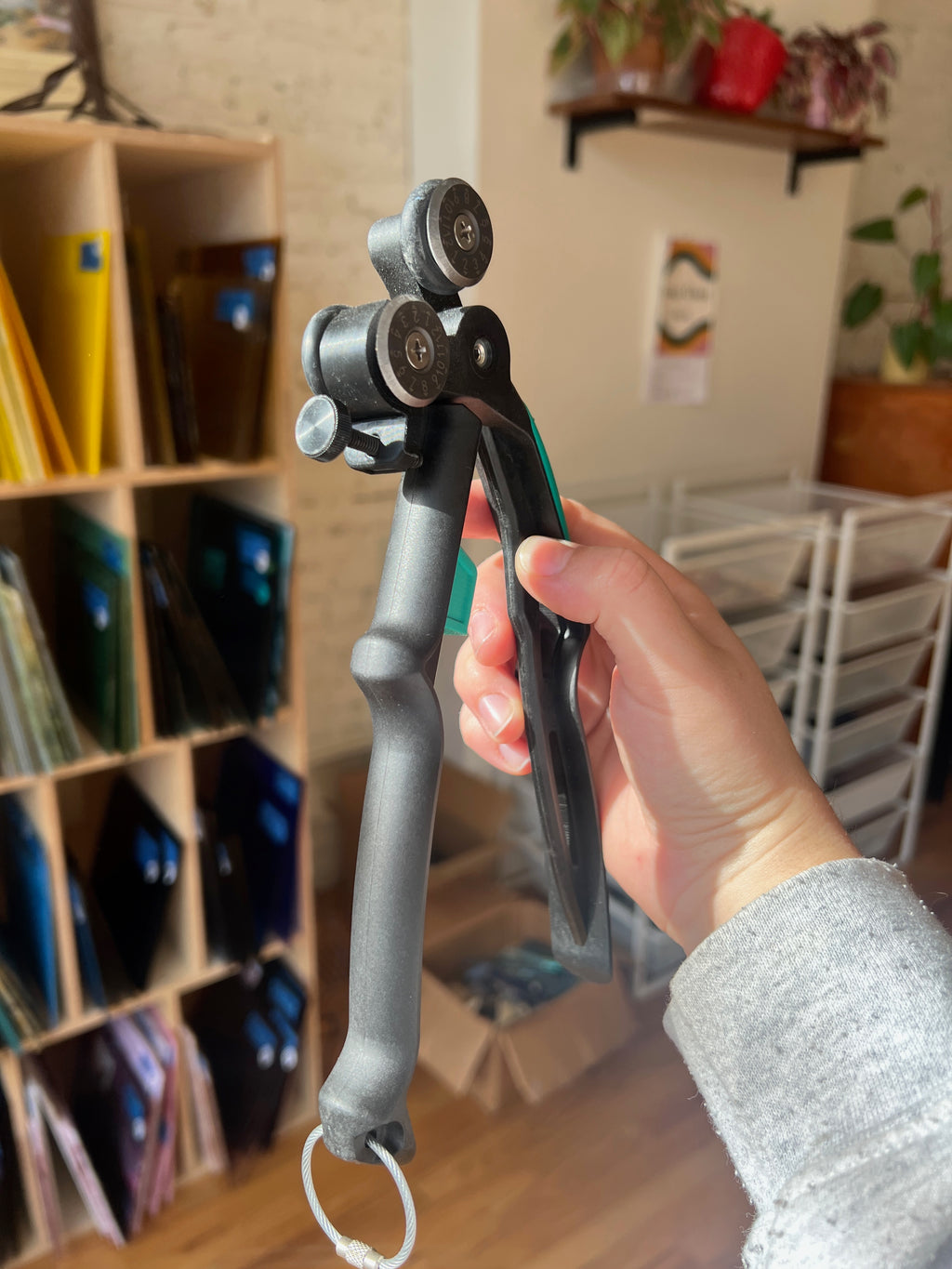 Hand holding a tool with a blurred indoor background