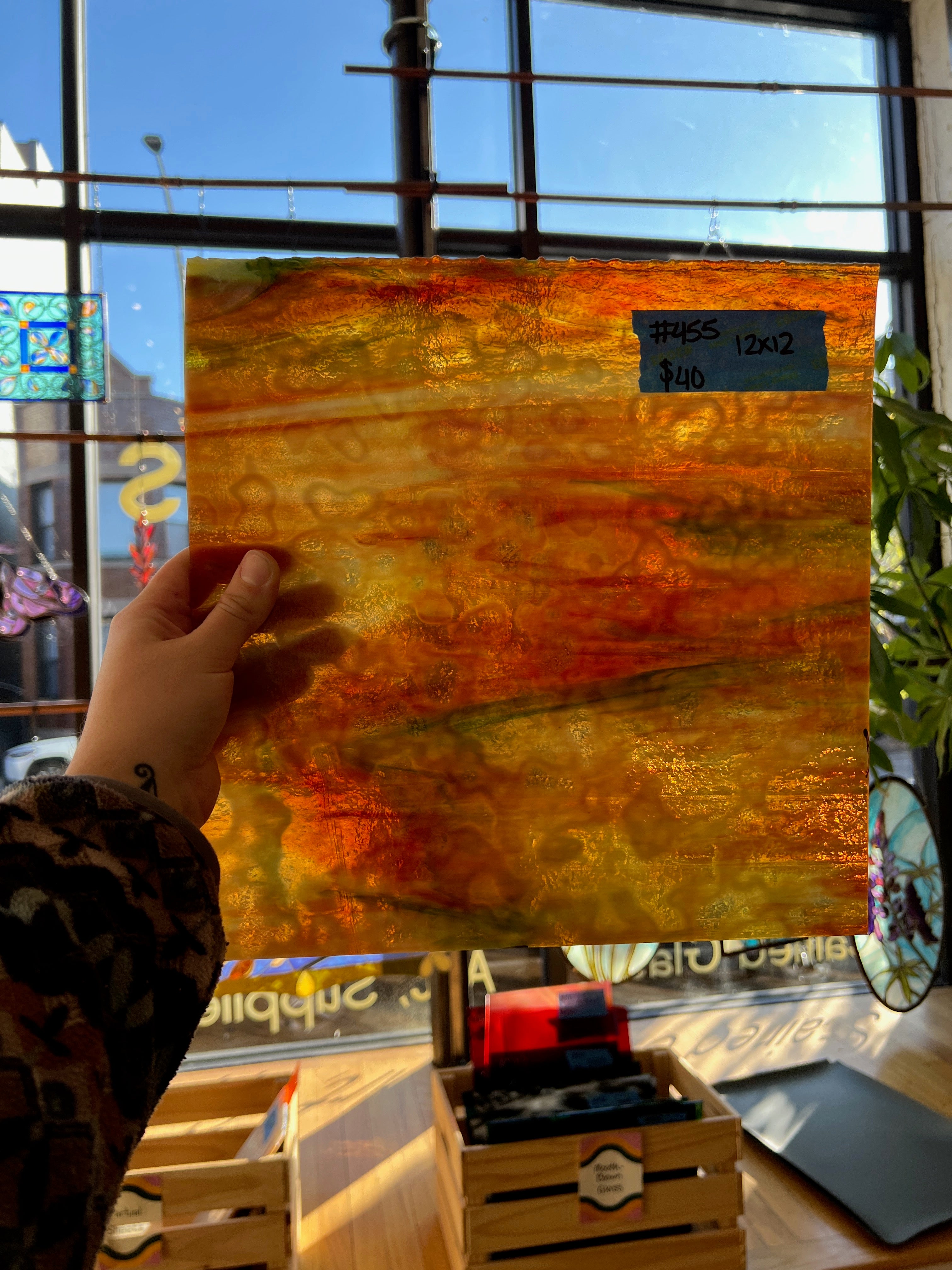 Hand holding a glass sheet with a cityscape background