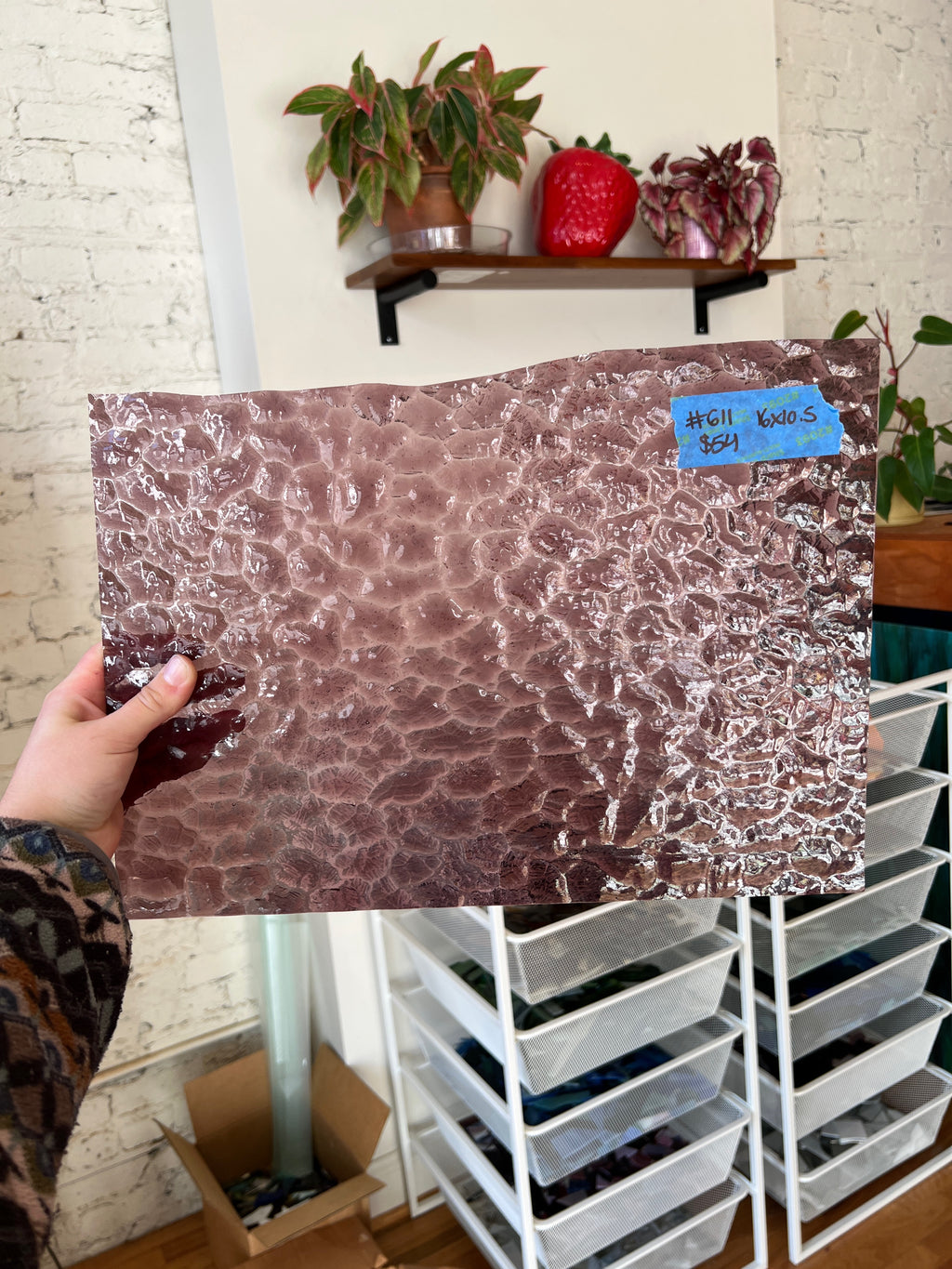 Person holding mauve sheet glass