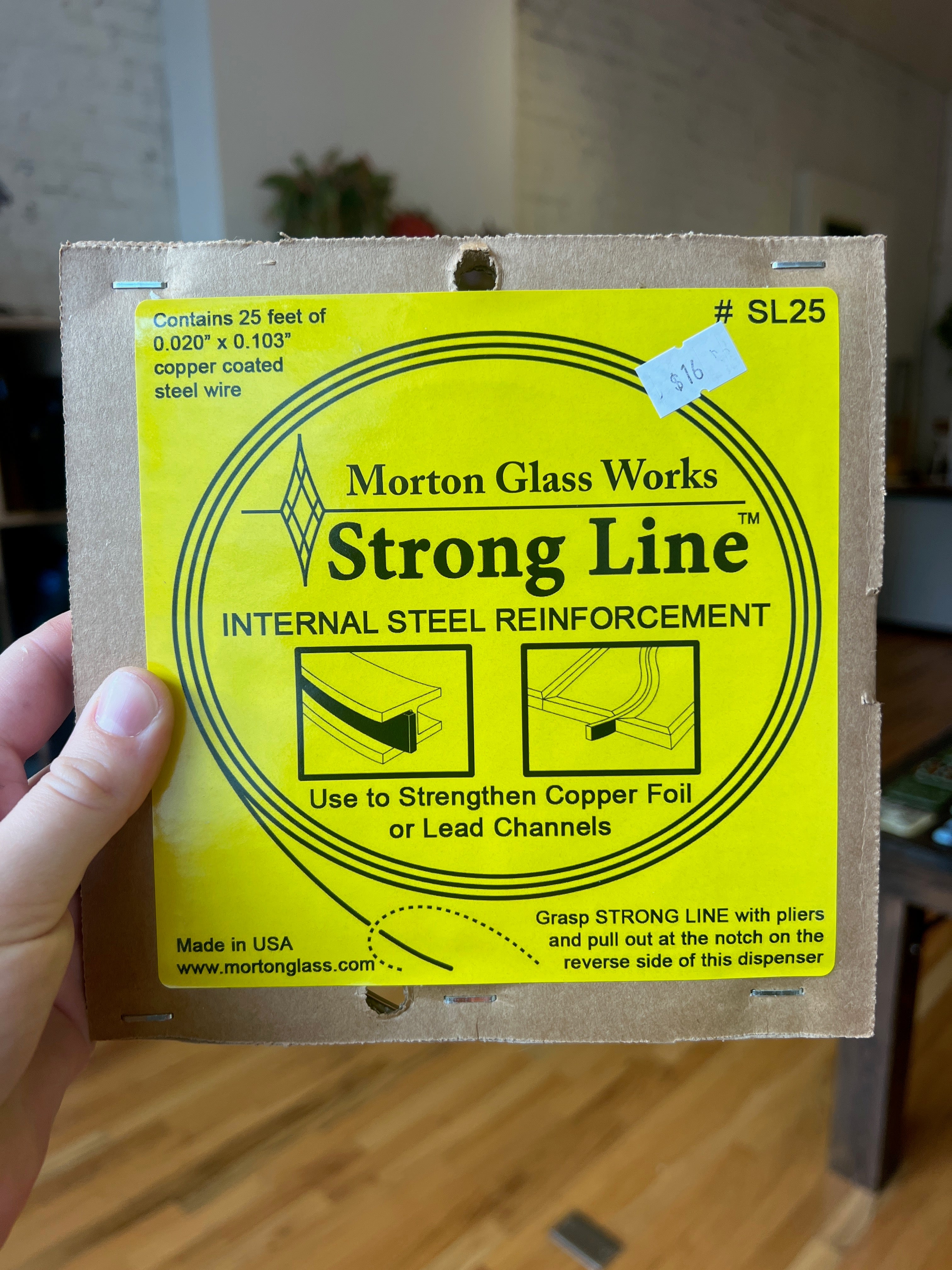 Morton Glass Works Strong Line packaging held by a hand with a blurred background