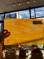 Glass sheet held by a hand with a blurred indoor background