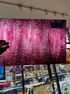 Large pink textured glass on a wall with a window view of a street scene.