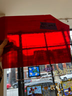 Red glass held up in front of a store window