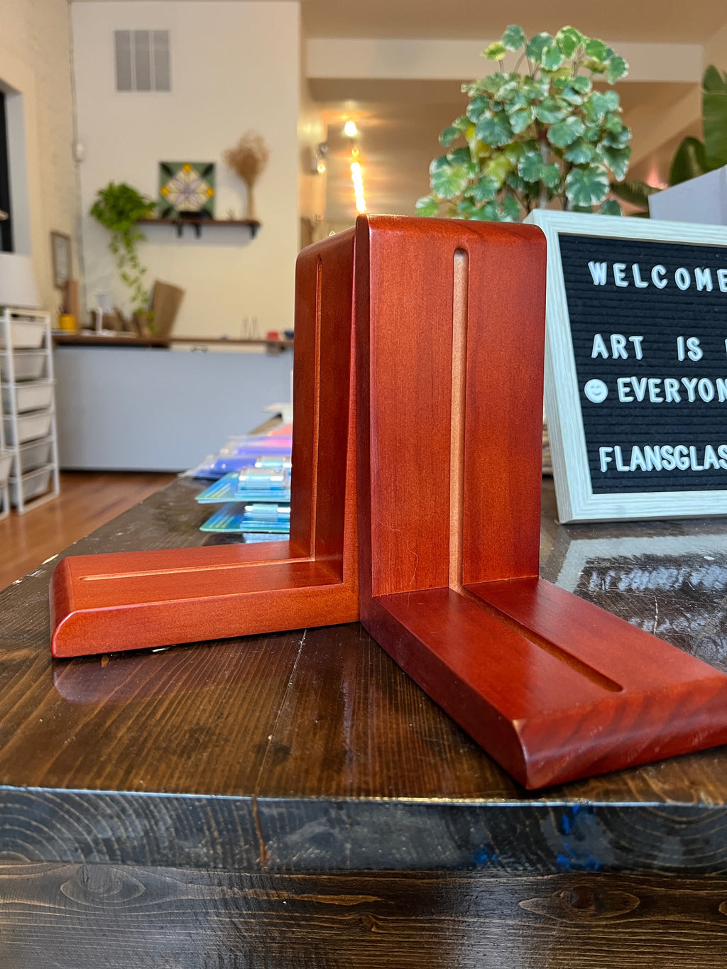Wooden bookends on a wooden surface with a blurred indoor background