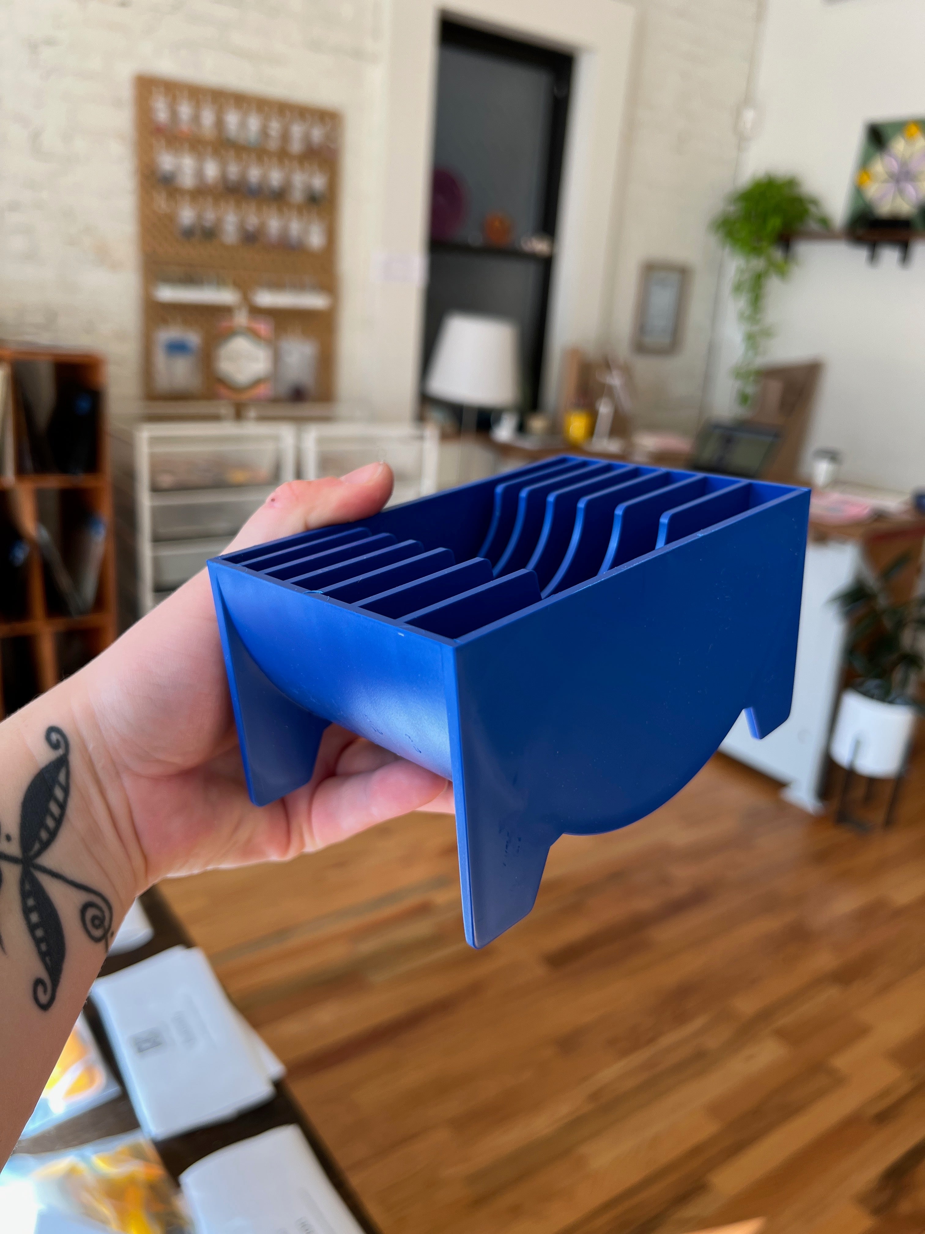 Hand holding a blue tool in a home setting