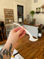 Hand holding a white tool with a blurred indoor setting