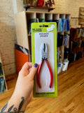 Hand holding a package of breaker grozer pliers in a store setting