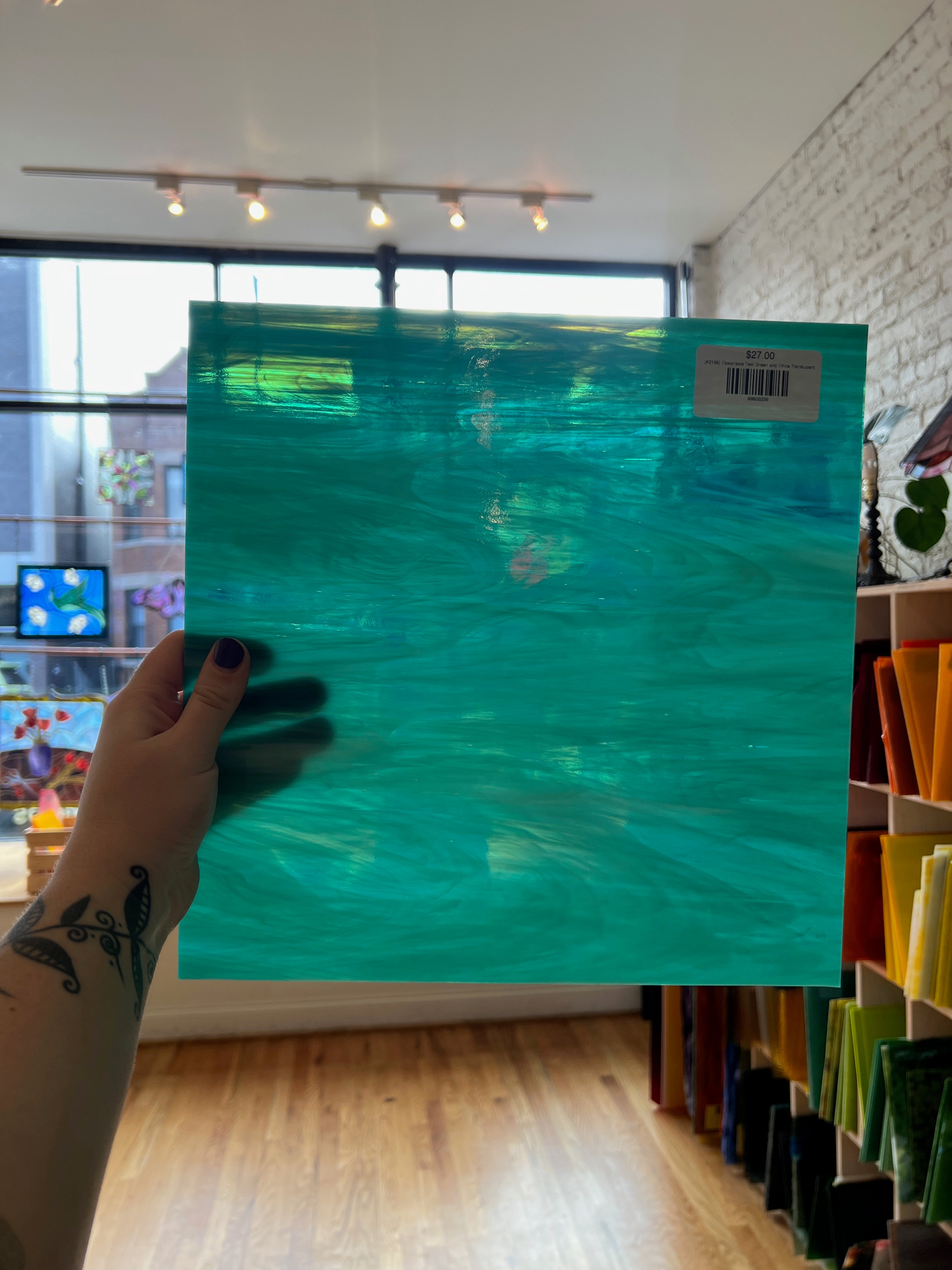 Turquoise sheet of glass held in front of a room with decor.