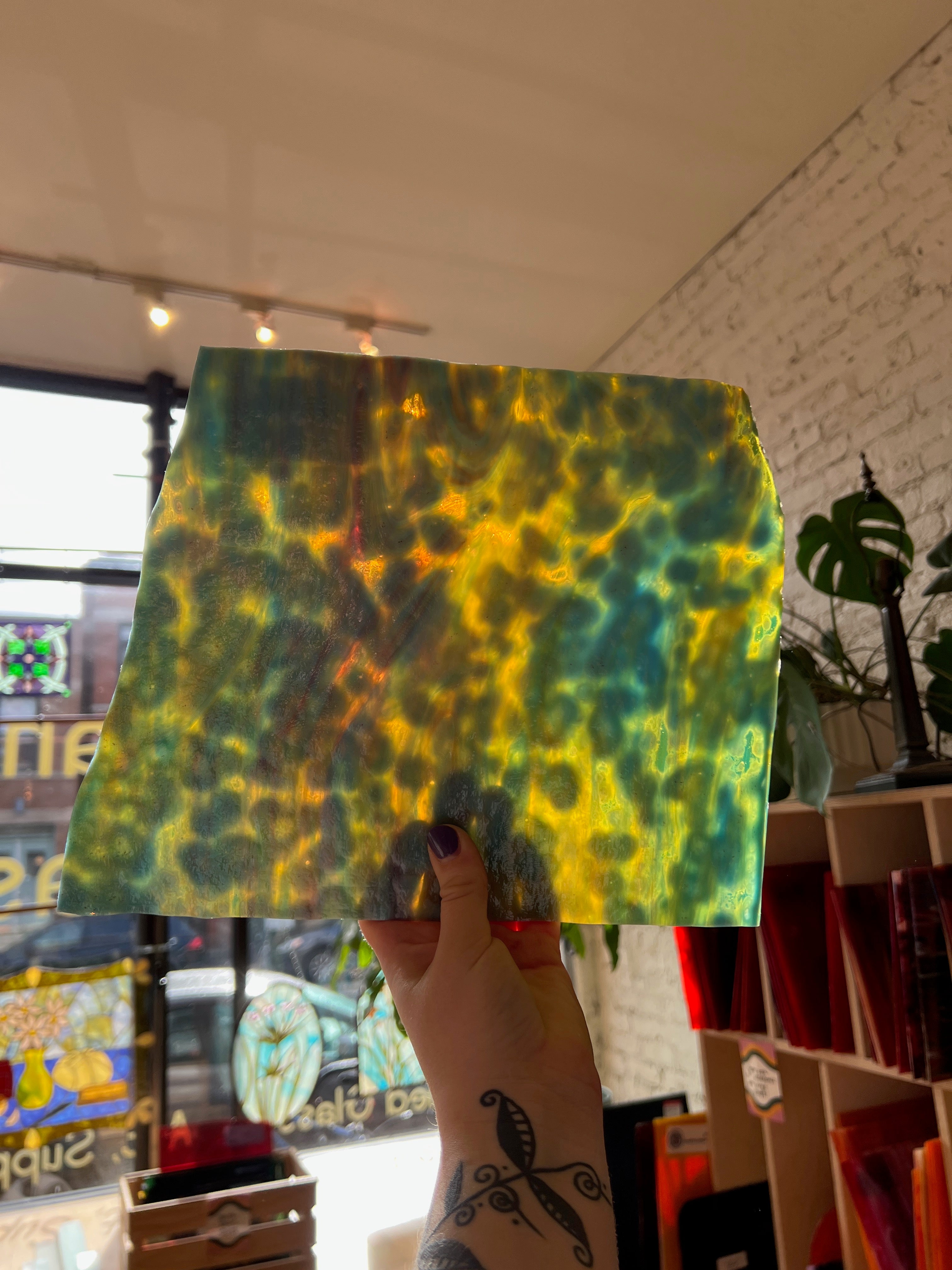 Colorful pattern on a piece of sheet glass held in front of a store window.