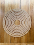 Round wooden pieces in concentric circles on a wooden floor