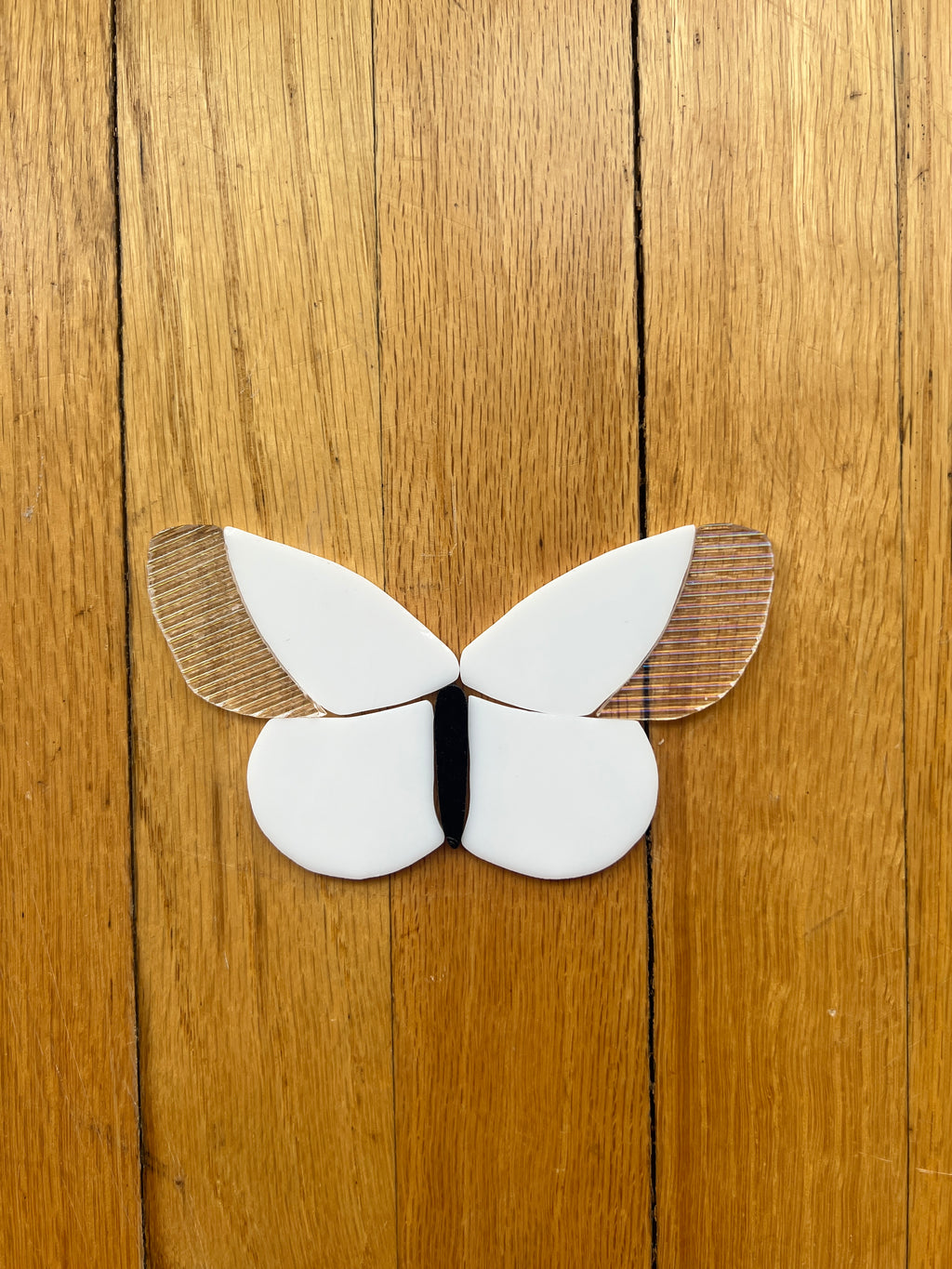 White glass butterfly on a wooden surface