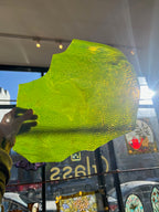 Large green piece of stained glass held up in front of a store window